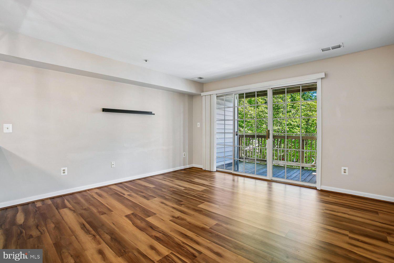 403 Fortress Way, Unit 403 Occoquan, VA 22125 - Photo 32 of 66 a view of an empty room with wooden floor and a window