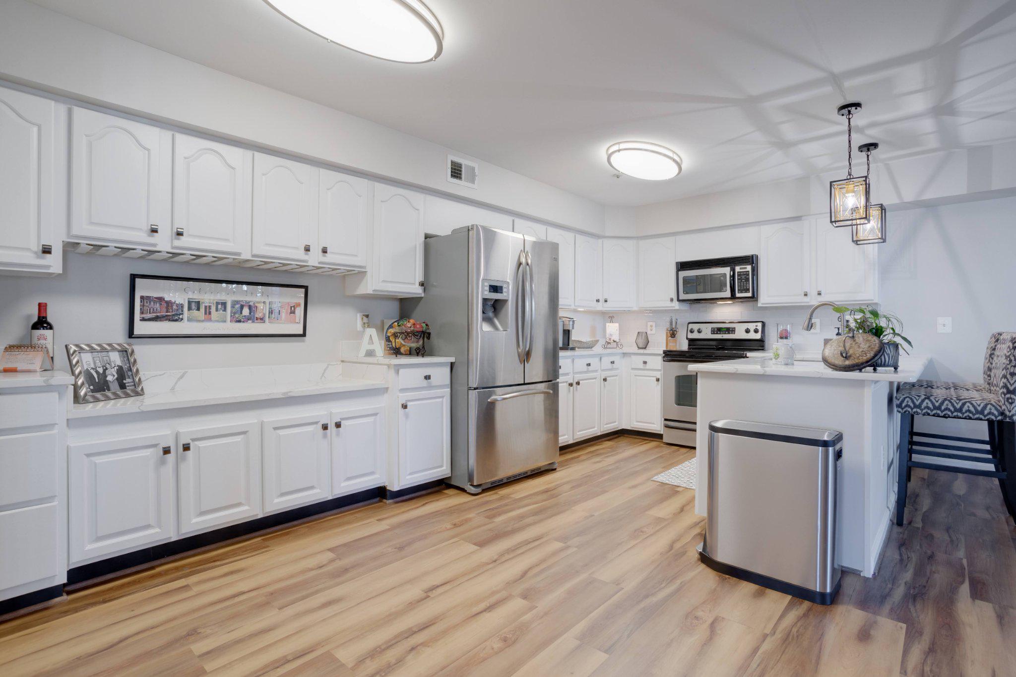 403 Fortress Way, Unit 403 Occoquan, VA 22125 - Photo 7 of 66 a kitchen with cabinets wooden floor and stainless steel appliances