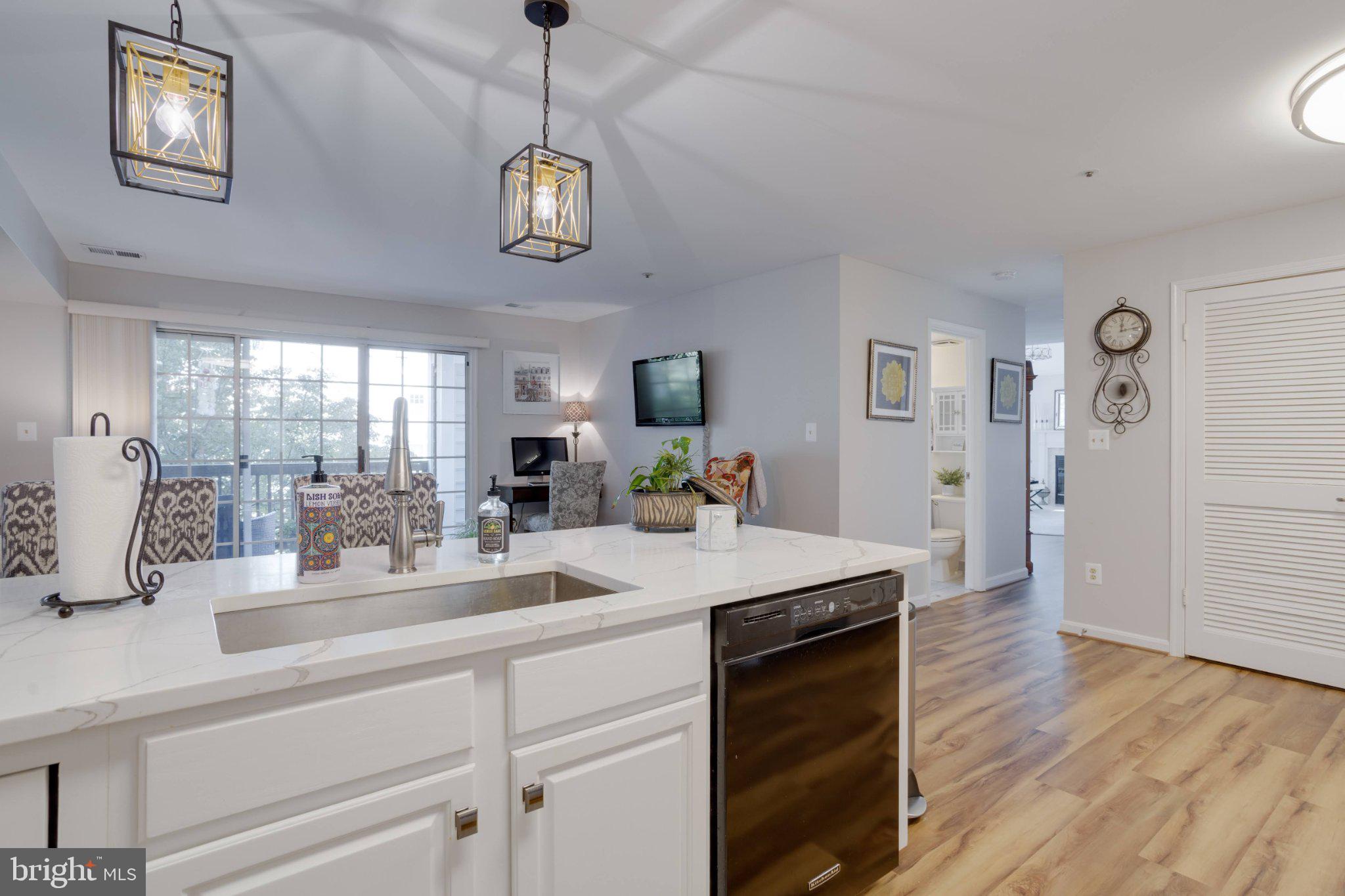 403 Fortress Way, Unit 403 Occoquan, VA 22125 - Photo 8 of 66 a dining hall with stainless steel appliances granite countertop a sink dishwasher and a fireplace with wooden floor