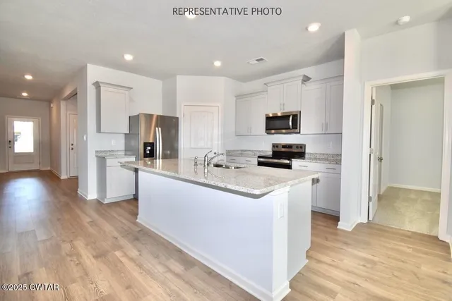 a kitchen with stainless steel appliances a refrigerator sink and microwave