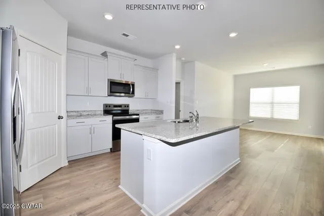 a kitchen with stainless steel appliances granite countertop a sink and microwave
