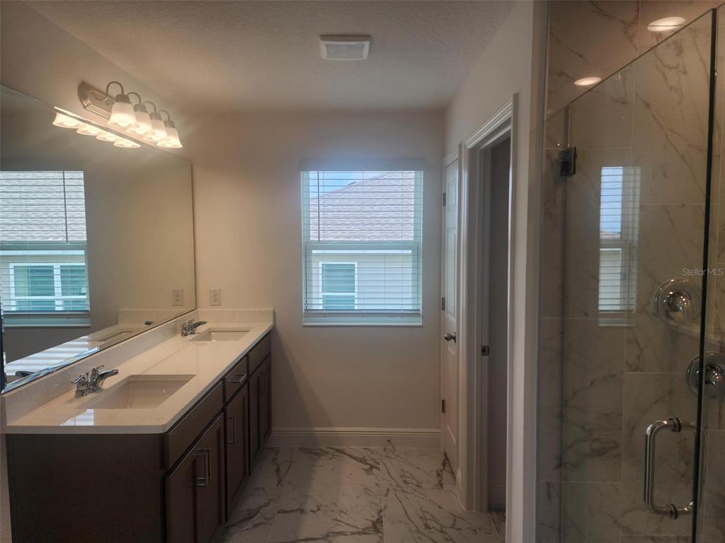 7501 Catania Loop Clermont, FL 34714 - Photo 9 of 12 a bathroom with a sink double vanity and shower