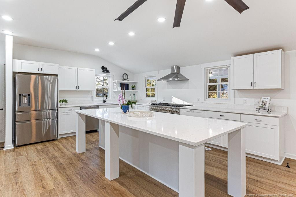 447 T T Johnson Road Carthage, NC 28327 - Photo 15 of 49 a kitchen with a sink a stove a refrigerator and white cabinets with wooden floor