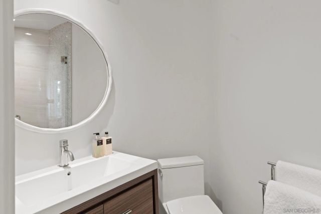 a bathroom with a sink mirror vanity and toilet