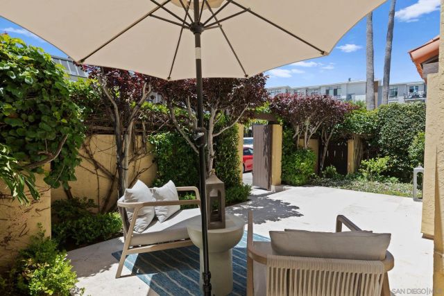 a view of a patio with table and chairs under an umbrella