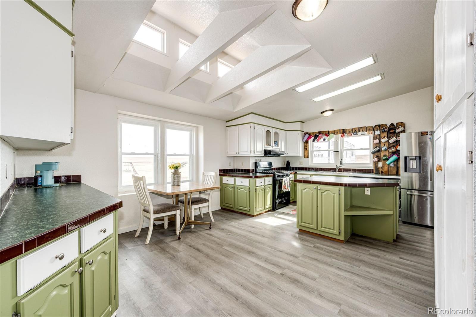26101 Flower Circle Simla, CO 80835 - Photo 9 of 48 a kitchen with a table chairs and a refrigerator