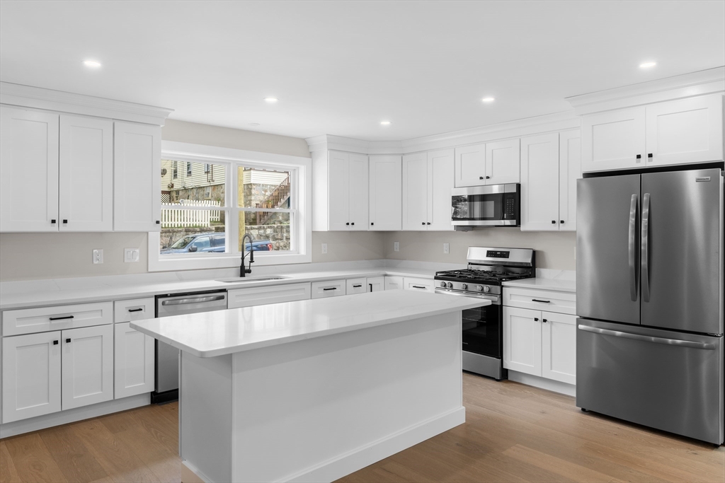 122 Stowe Street, Unit 122 Fall River, MA 02720 - Photo 16 of 26 a kitchen with a sink white cabinets and stainless steel appliances