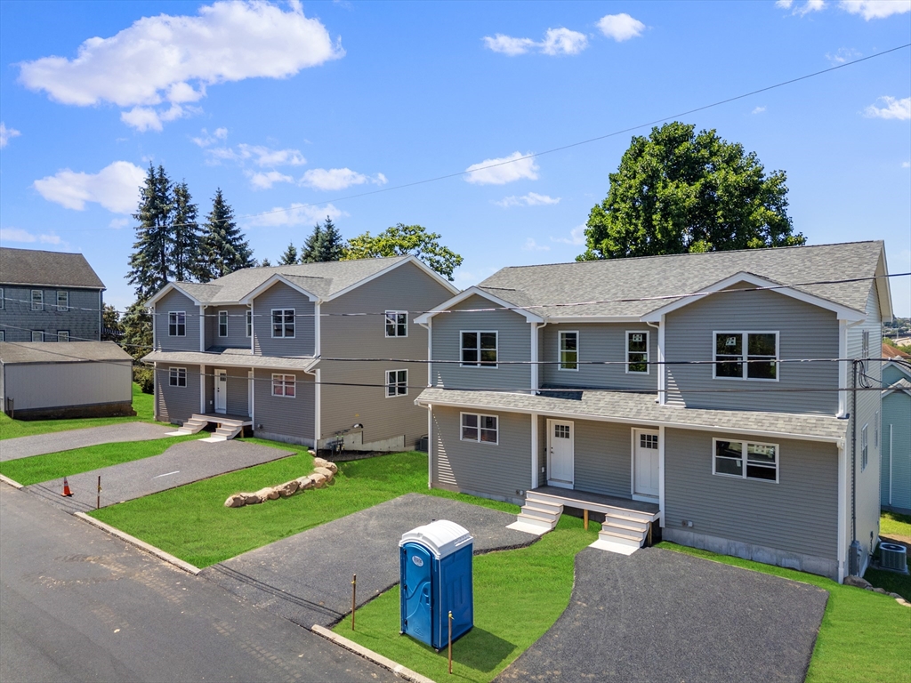 122 Stowe Street, Unit 122 Fall River, MA 02720 - Photo 2 of 26 a front view of a house with a yard table and chairs