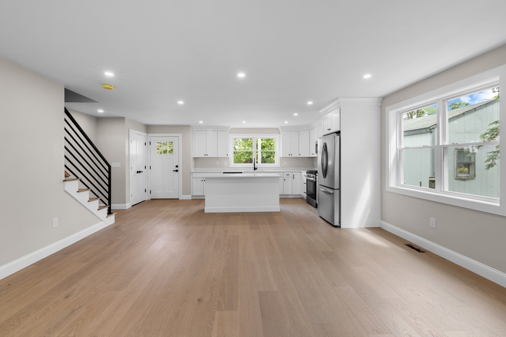122 Stowe Street, Unit 122 Fall River, MA 02720 - Photo 6 of 26 a view of a kitchen with a fridge and wooden floor
