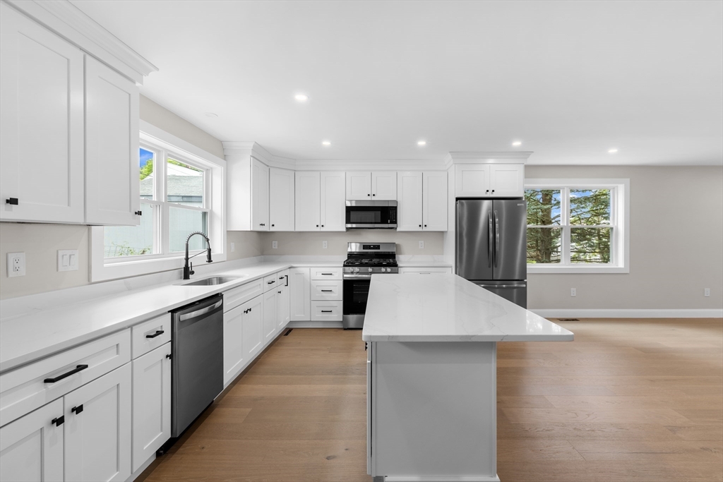 122 Stowe Street, Unit 122 Fall River, MA 02720 - Photo 7 of 26 a kitchen with granite countertop white cabinets and white appliances