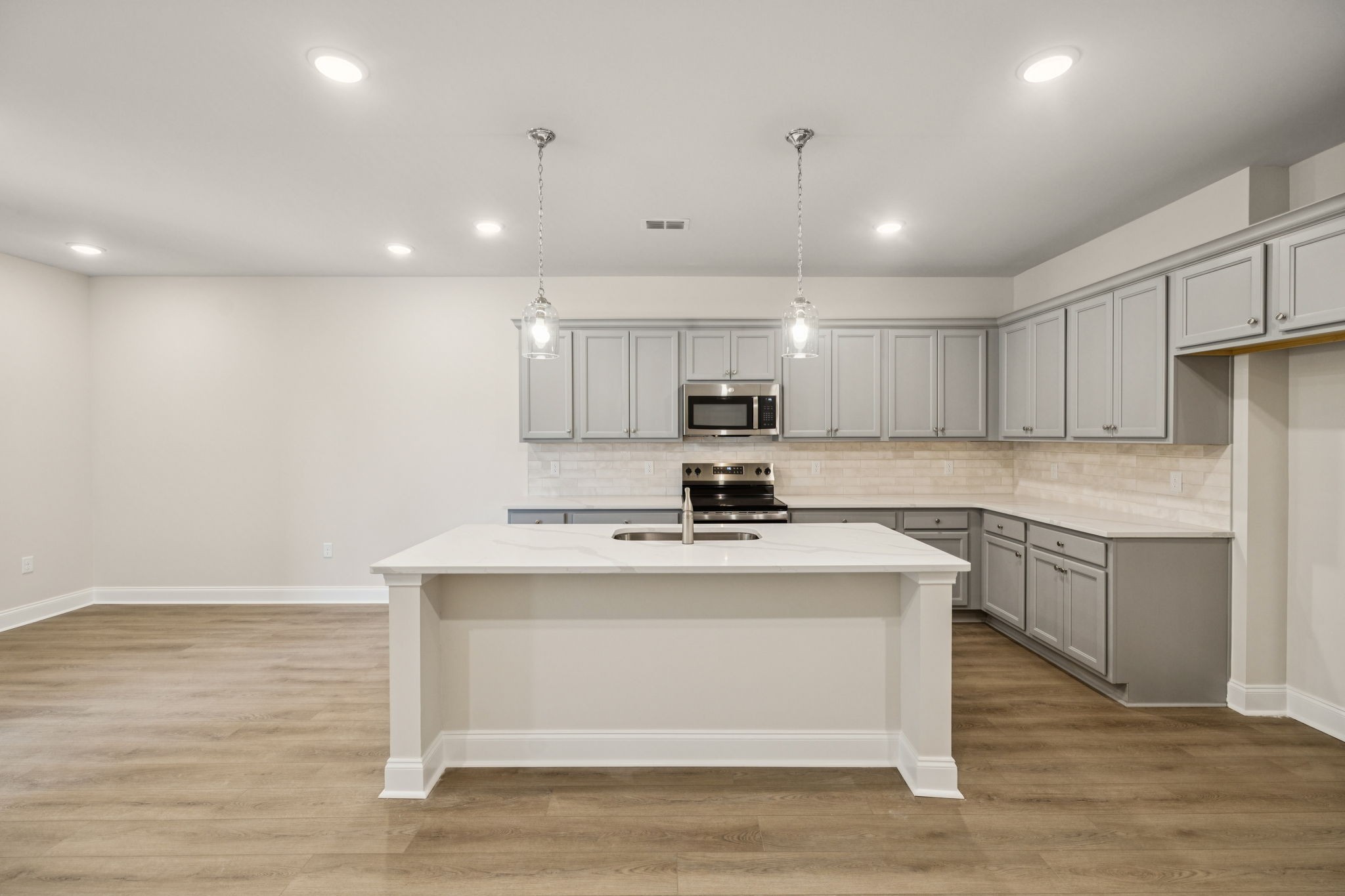 8140 Rocky Fork Almaville Road Smyrna, TN 37167 - Photo 23 of 43 a kitchen with stainless steel appliances granite countertop a sink a stove a refrigerator and white cabinets with wooden floor
