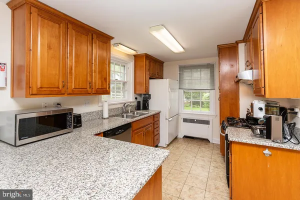 a kitchen with stainless steel appliances granite countertop wooden cabinets a stove top oven a sink and dishwasher