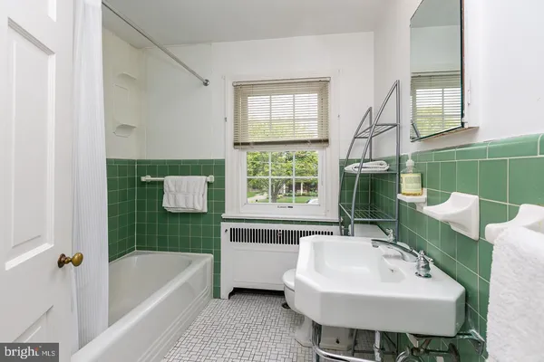 a bathroom with a sink a bathtub and a window