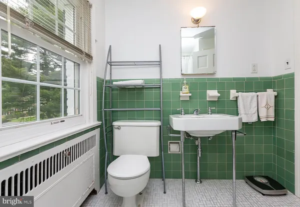 a bathroom with a toilet a sink and mirror