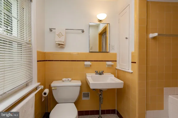 a bathroom with a toilet a sink and a mirror