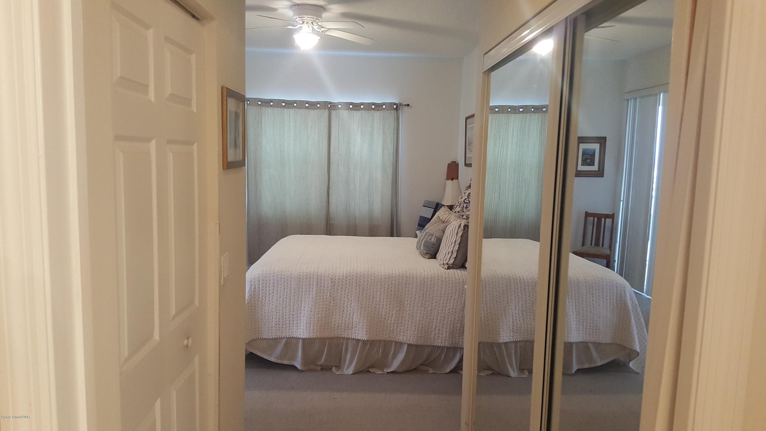 100 Riverside Drive, Unit 804 Cocoa, FL 32922 - Photo 10 of 11 a bedroom with a bed and a mirror