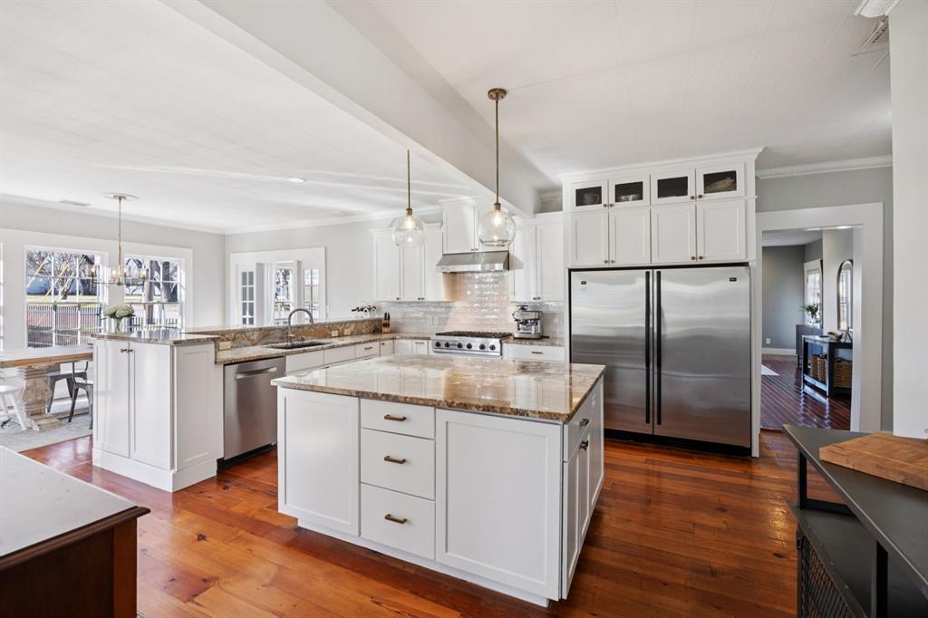 704 Williams Street Rockwall, TX 75087 - Photo 16 of 39 a kitchen with kitchen island white cabinets and stainless steel appliances