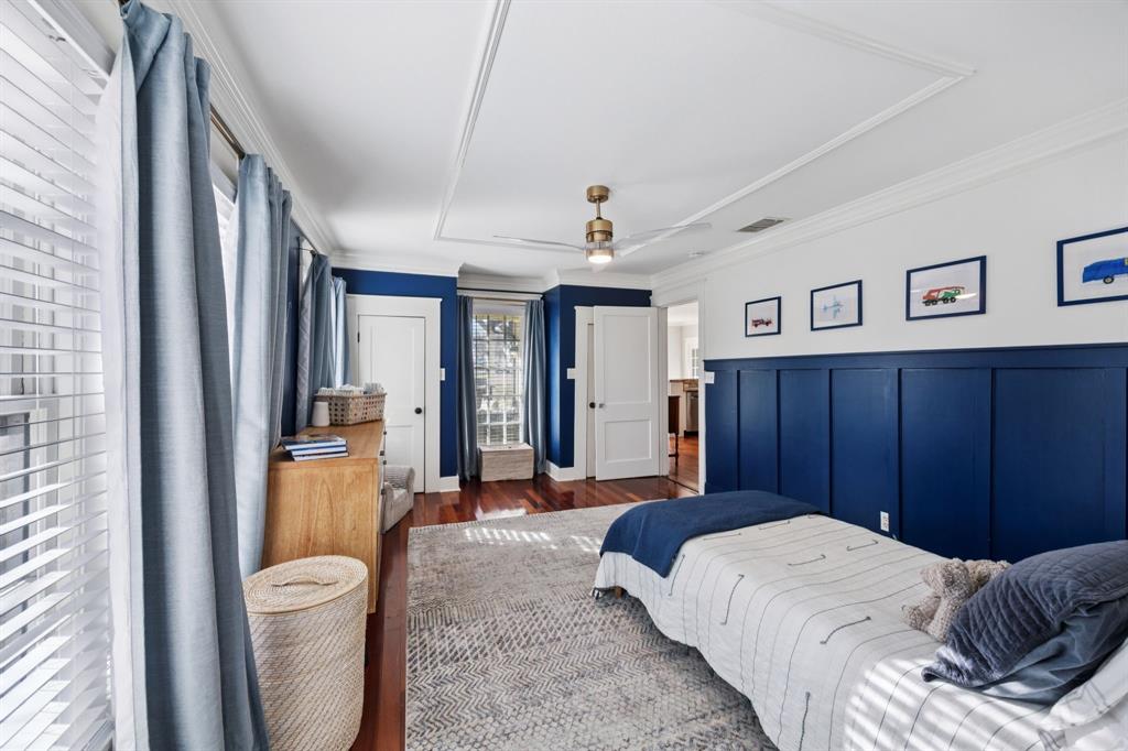 704 Williams Street Rockwall, TX 75087 - Photo 26 of 39 a spacious bedroom with a bed and a chandelier