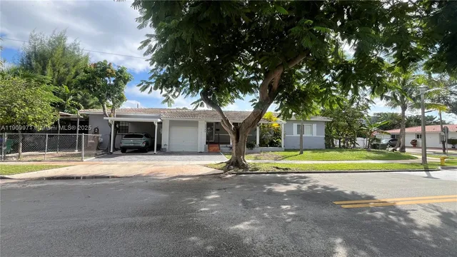 a front view of a house with a yard and trees