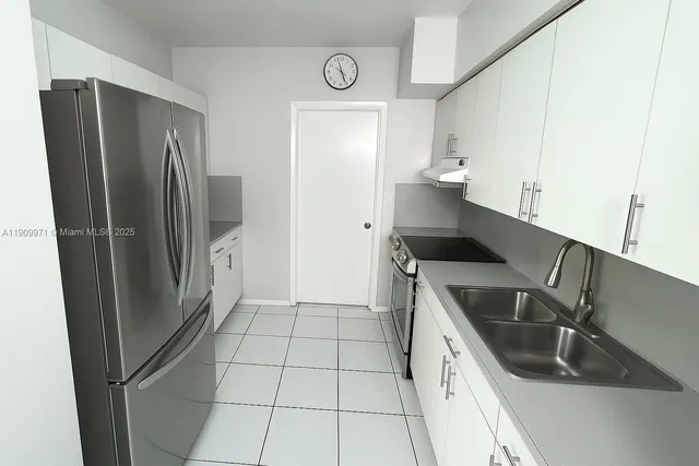 a kitchen with a refrigerator sink and cabinets