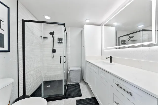 a bathroom with a shower sink and toilet