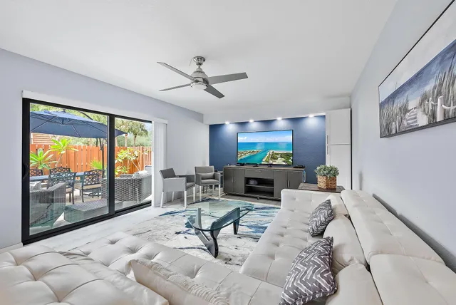 a living room with furniture a chandelier and a floor to ceiling window