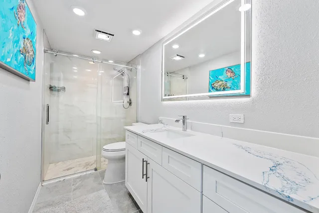 a bathroom with a sink a toilet and shower