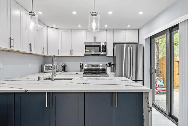 a kitchen with stainless steel appliances granite countertop a sink refrigerator and cabinets