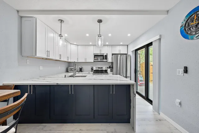 a kitchen with kitchen island granite countertop a sink window and cabinets