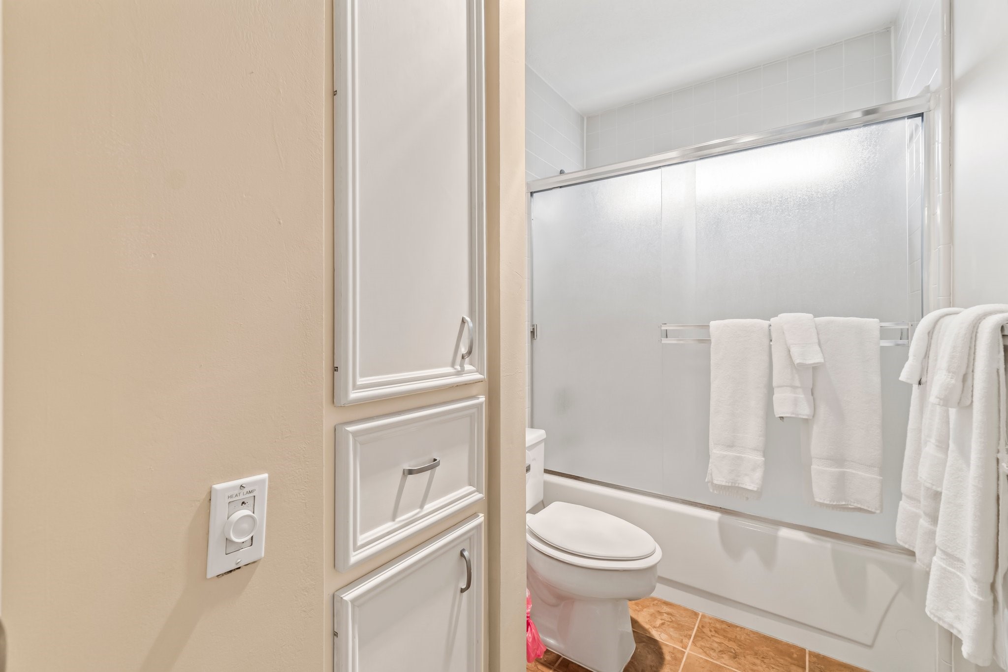 2839 Hemingway Drive Montgomery, TX 77356 - Photo 24 of 49 This bathroom features a clean design with a sliding glass shower door, white cabinetry, and tiled flooring. It offers ample storage and a bright, welcoming atmosphere.
