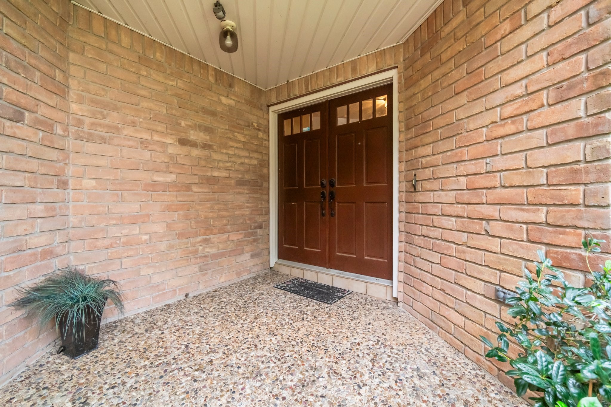 2839 Hemingway Drive Montgomery, TX 77356 - Photo 4 of 49 This welcoming entrance features a classic brick exterior, a sturdy double wooden door, and a textured stone floor. Subtle greenery adds a touch of warmth and charm.