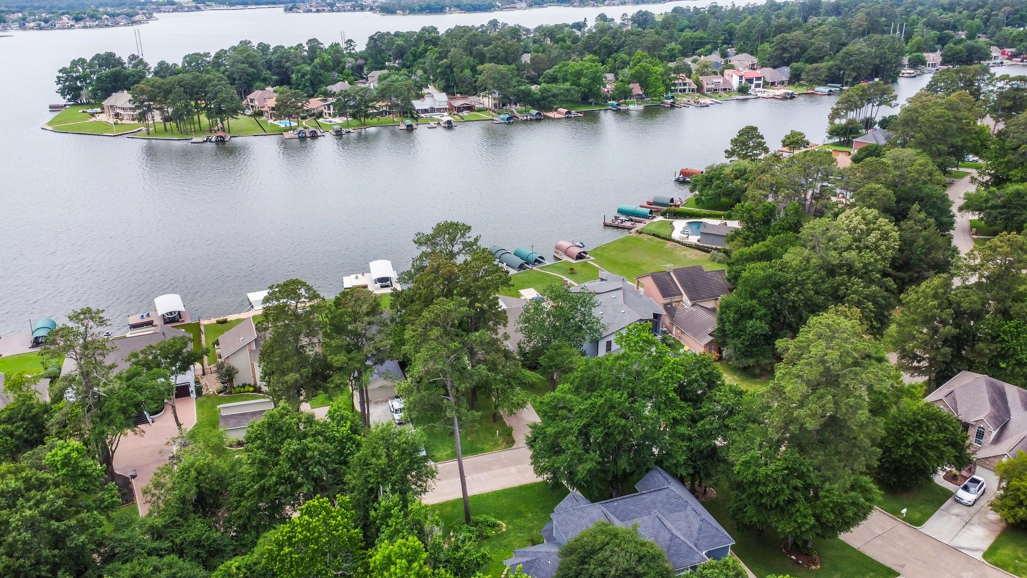 2839 Hemingway Drive Montgomery, TX 77356 - Photo 45 of 49 This aerial photo showcases a peaceful lakeside neighborhood with homes nestled among lush greenery. The properties have direct access to the water, offering potential for private docks and beautiful views. Ideal for those seeking a serene waterfront lifestyle.