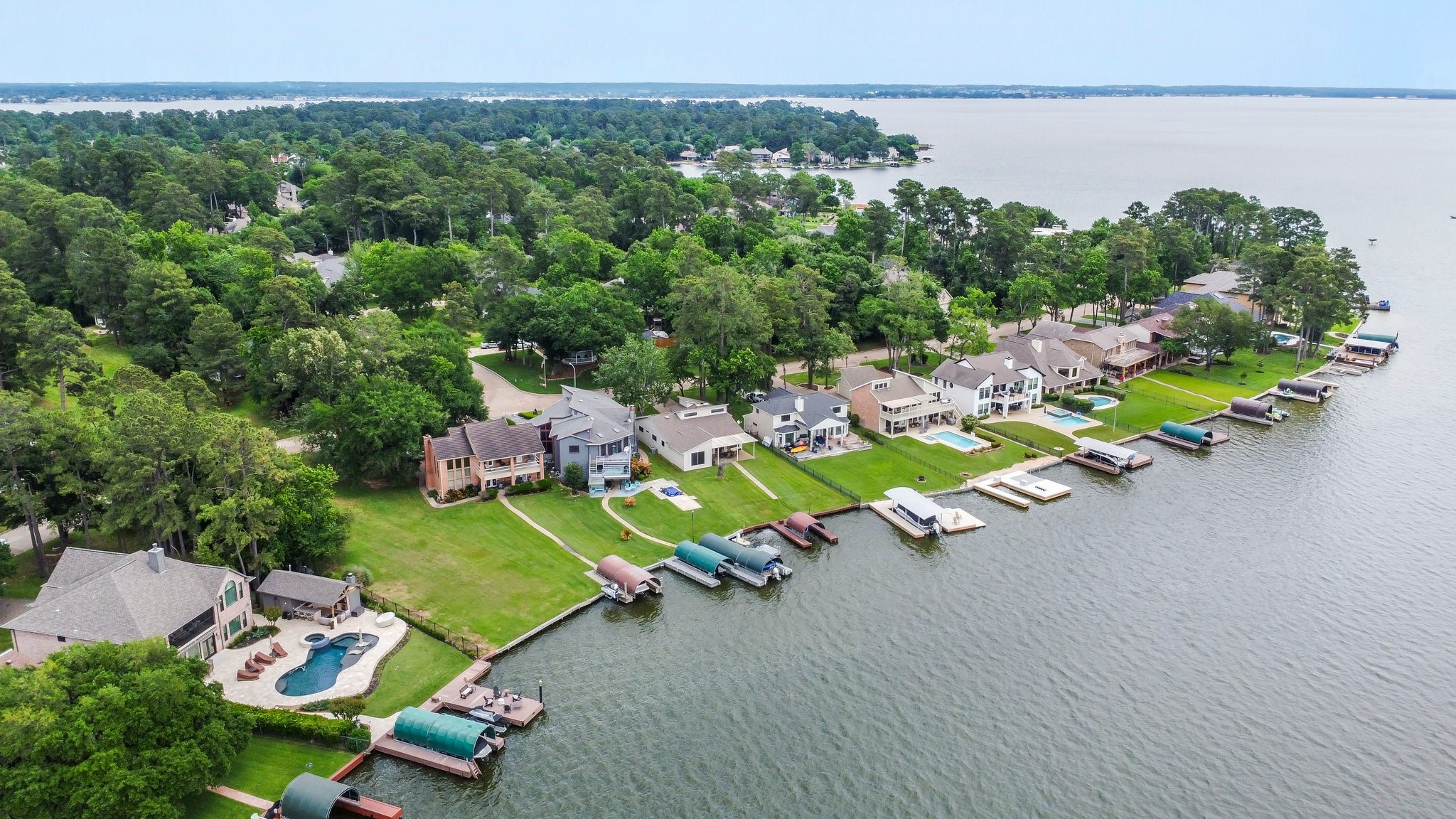 2839 Hemingway Drive Montgomery, TX 77356 - Photo 47 of 49 This photo showcases a beautiful lakeside neighborhood with spacious homes, lush greenery, and private docks. Ideal for those seeking waterfront living and scenic views.