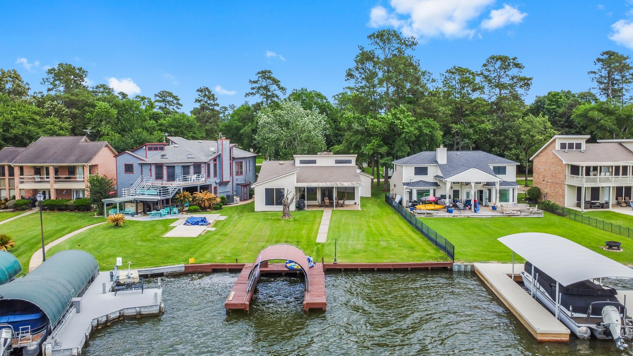 2839 Hemingway Drive Montgomery, TX 77356 - Photo 48 of 49 This waterfront property features a spacious backyard with a private dock, ideal for boating enthusiasts. The home is surrounded by lush greenery and neighboring houses, offering a serene and picturesque setting. Perfect for those seeking a tranquil lifestyle by the water.