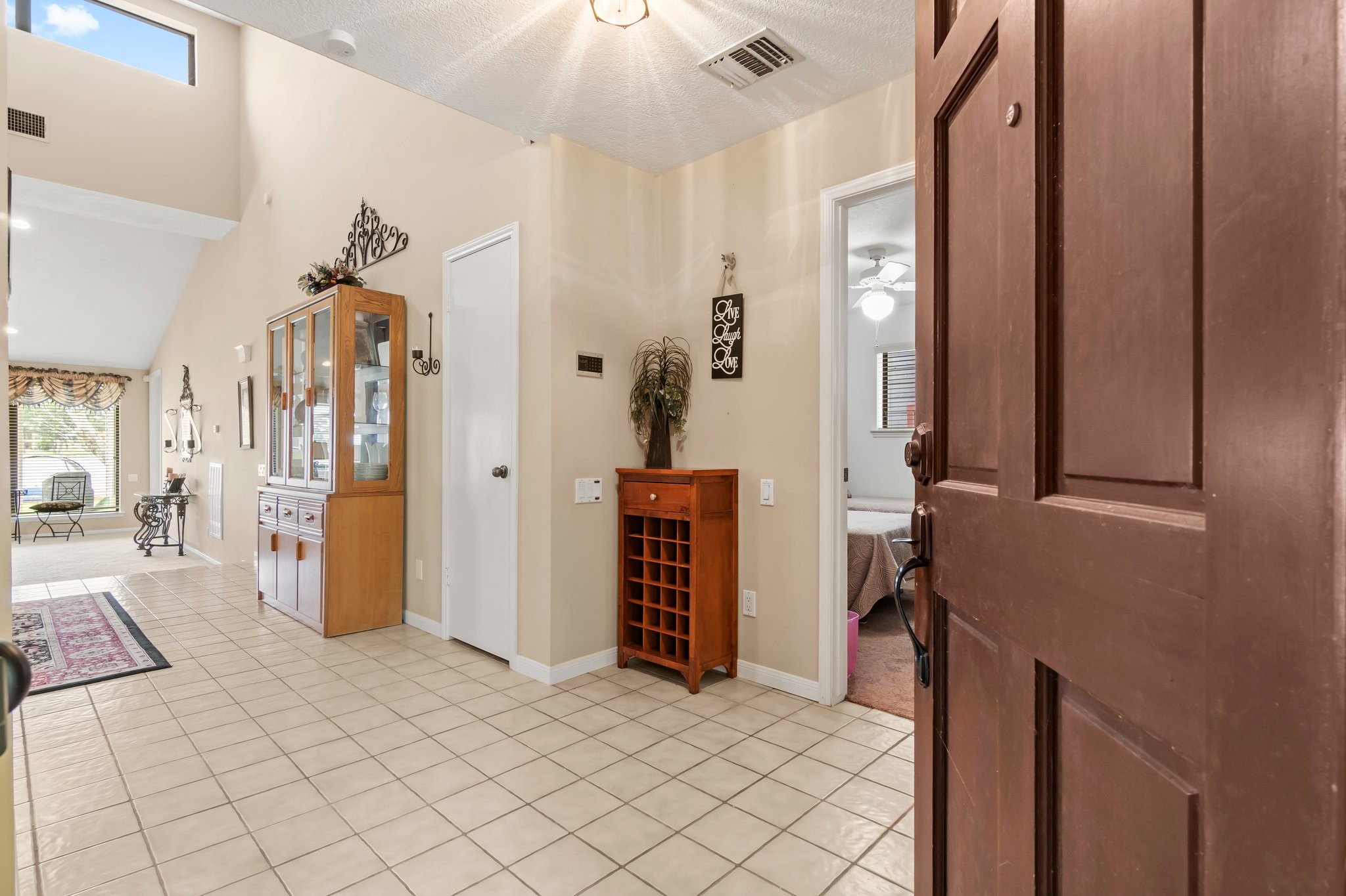 2839 Hemingway Drive Montgomery, TX 77356 - Photo 5 of 49 This inviting entryway features tiled flooring, a high ceiling, and ample natural light. It opens to a spacious living area with a large window and includes a stylish cabinet and decorative wall accents.