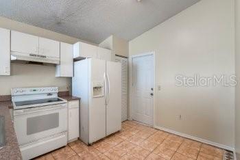 1032 Inkberry Court Orlando, FL 32811 - Photo 5 of 16 a kitchen with white cabinets and white appliances