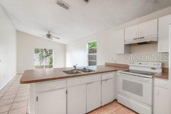 1032 Inkberry Court Orlando, FL 32811 - Photo 6 of 16 a kitchen with appliances cabinets and a sink