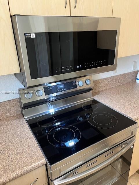 12080 Southwest 268th Street, Unit 28 Homestead, FL 33032 - Photo 5 of 25 a close view of a stove a microwave and cabinets