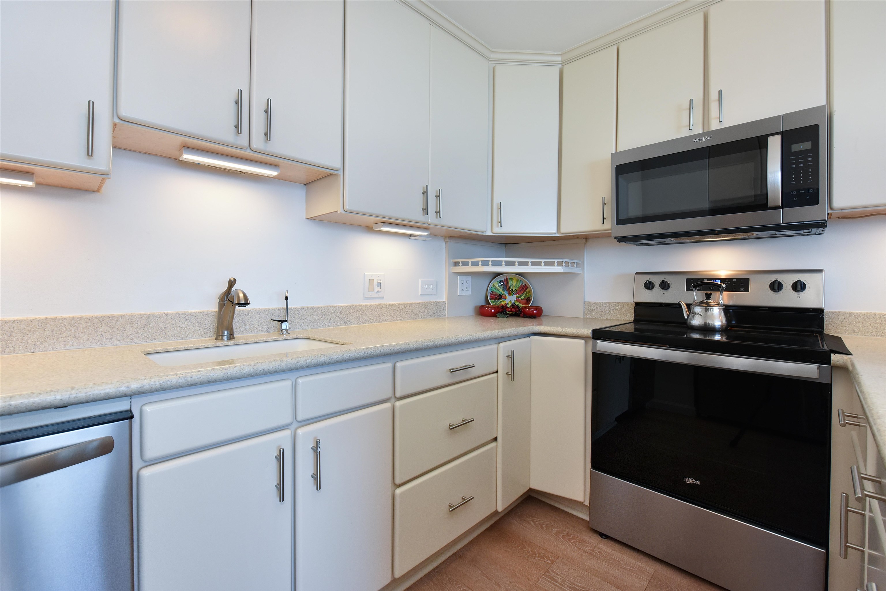 1403 Front Street, Unit 308 Lahaina, HI 96761 - Photo 12 of 35 a kitchen with white cabinets and stainless steel appliances