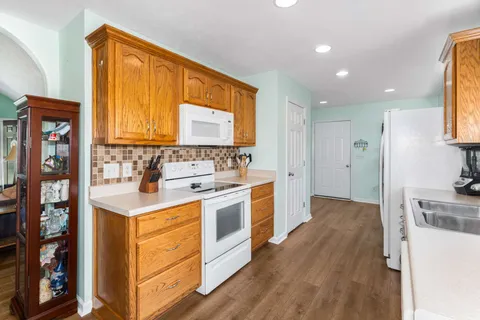 a kitchen with stainless steel appliances granite countertop a sink stove and wooden cabinets