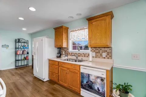a kitchen with stainless steel appliances granite countertop a sink a stove and a refrigerator