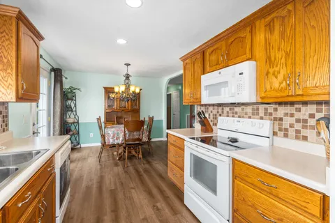 a kitchen with stainless steel appliances a stove a sink dishwasher and cabinets with wooden floor