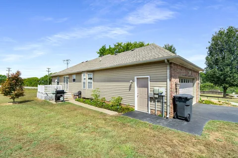 a backyard of a house with table and chairs