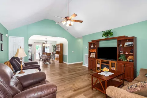 a living room with furniture a flat screen tv and a large window