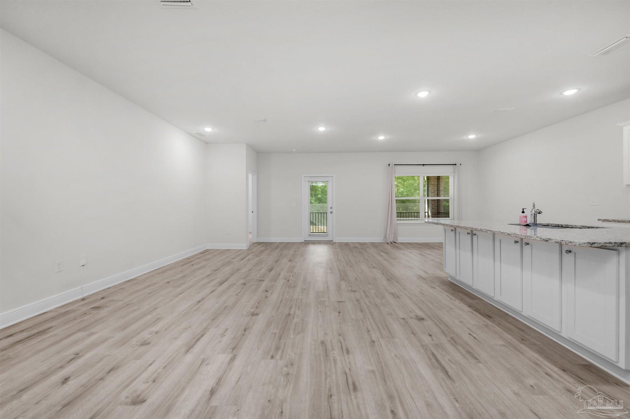 7814 Burnside Loop Pensacola, FL 32526 - Photo 14 of 41 an empty room with wooden floor and windows