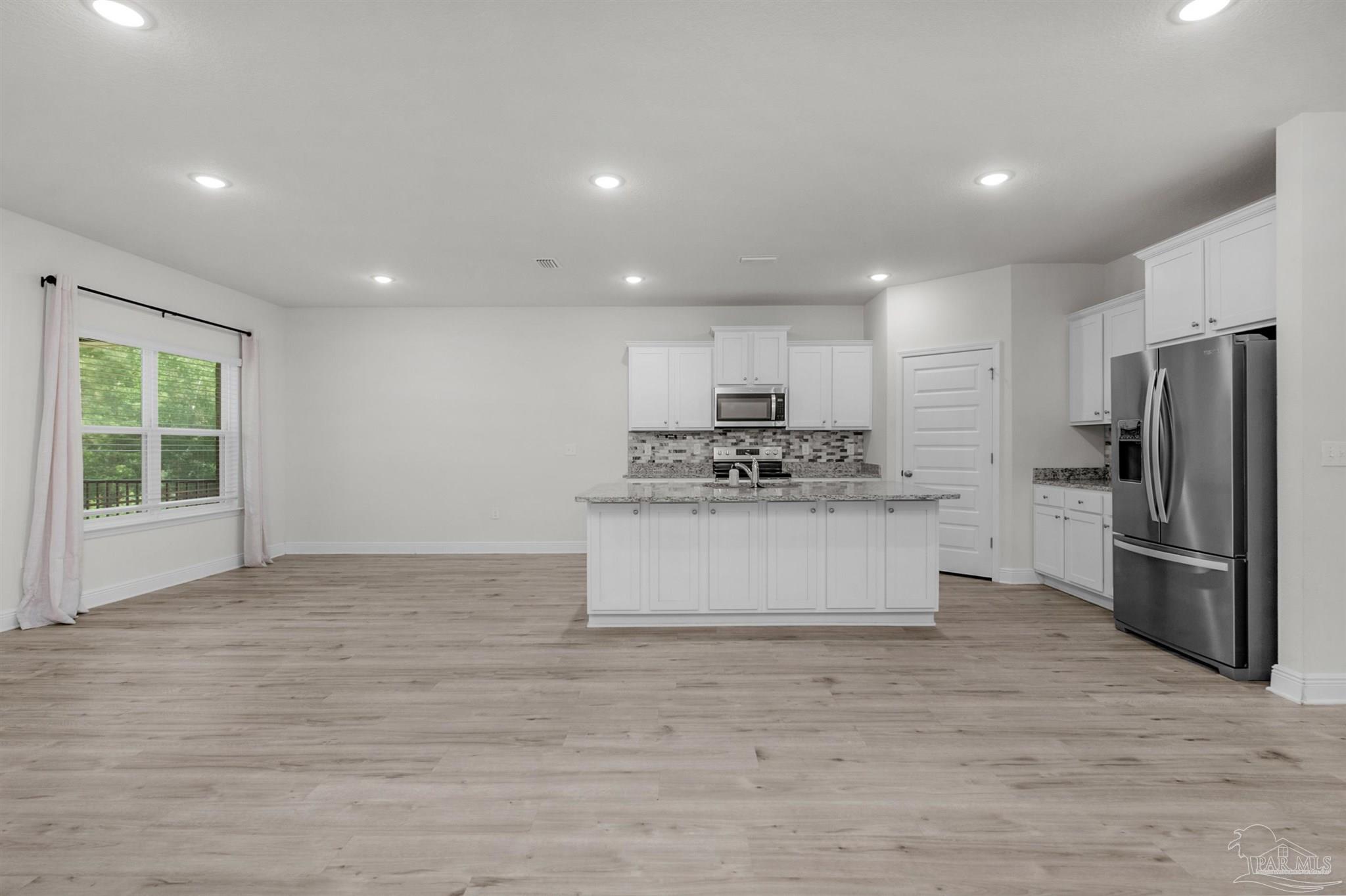 7814 Burnside Loop Pensacola, FL 32526 - Photo 16 of 41 a kitchen with stainless steel appliances a refrigerator sink and stove