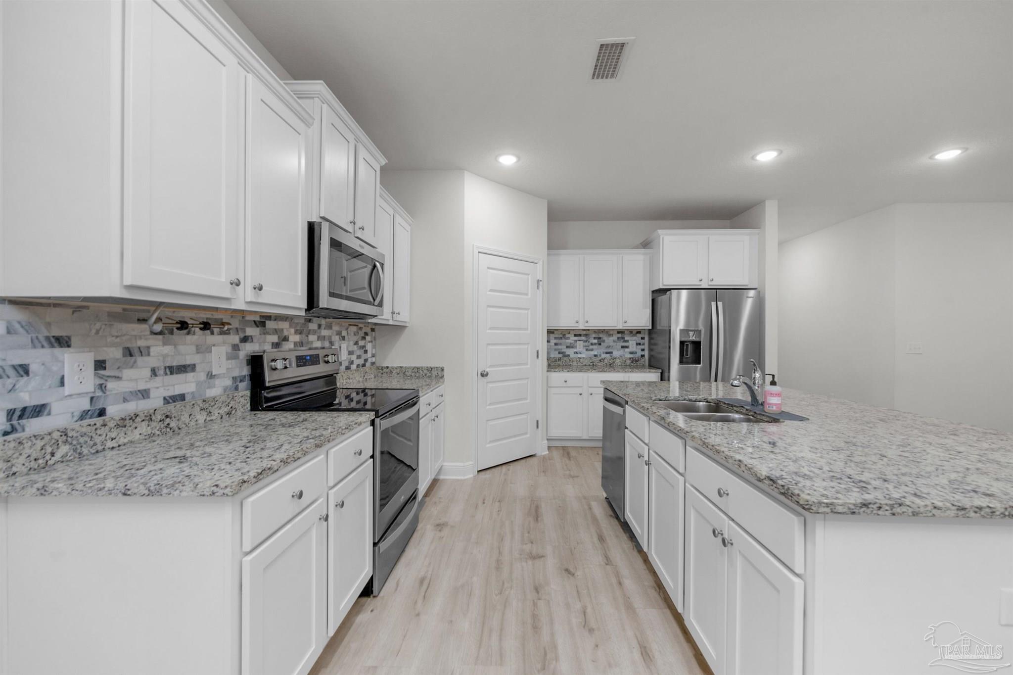 7814 Burnside Loop Pensacola, FL 32526 - Photo 21 of 41 a kitchen with stainless steel appliances granite countertop wooden cabinets granite counter tops and a hard wood floors
