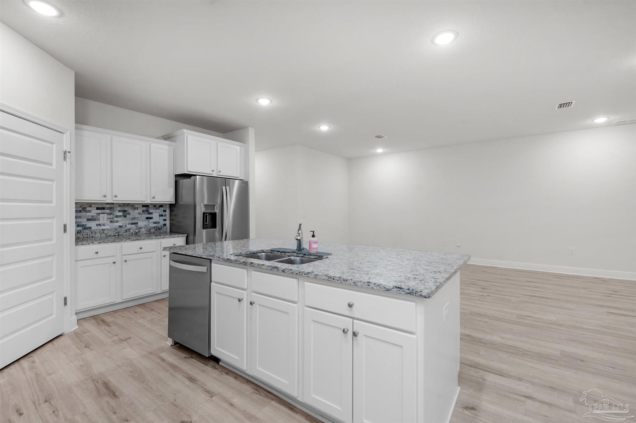 7814 Burnside Loop Pensacola, FL 32526 - Photo 22 of 41 a kitchen with white cabinets and stainless steel appliances