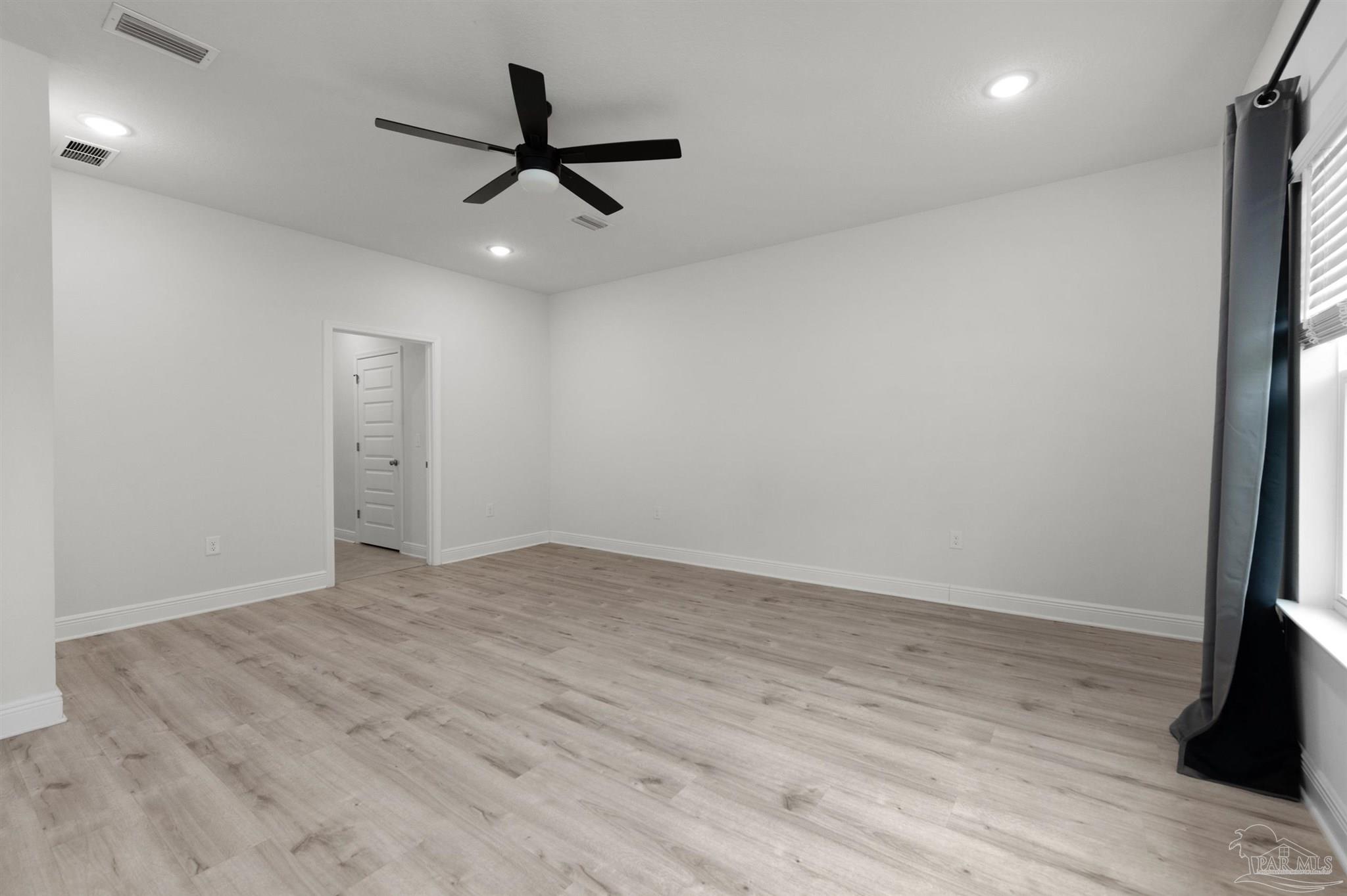 7814 Burnside Loop Pensacola, FL 32526 - Photo 26 of 41 an empty room with wooden floor and a ceiling fan