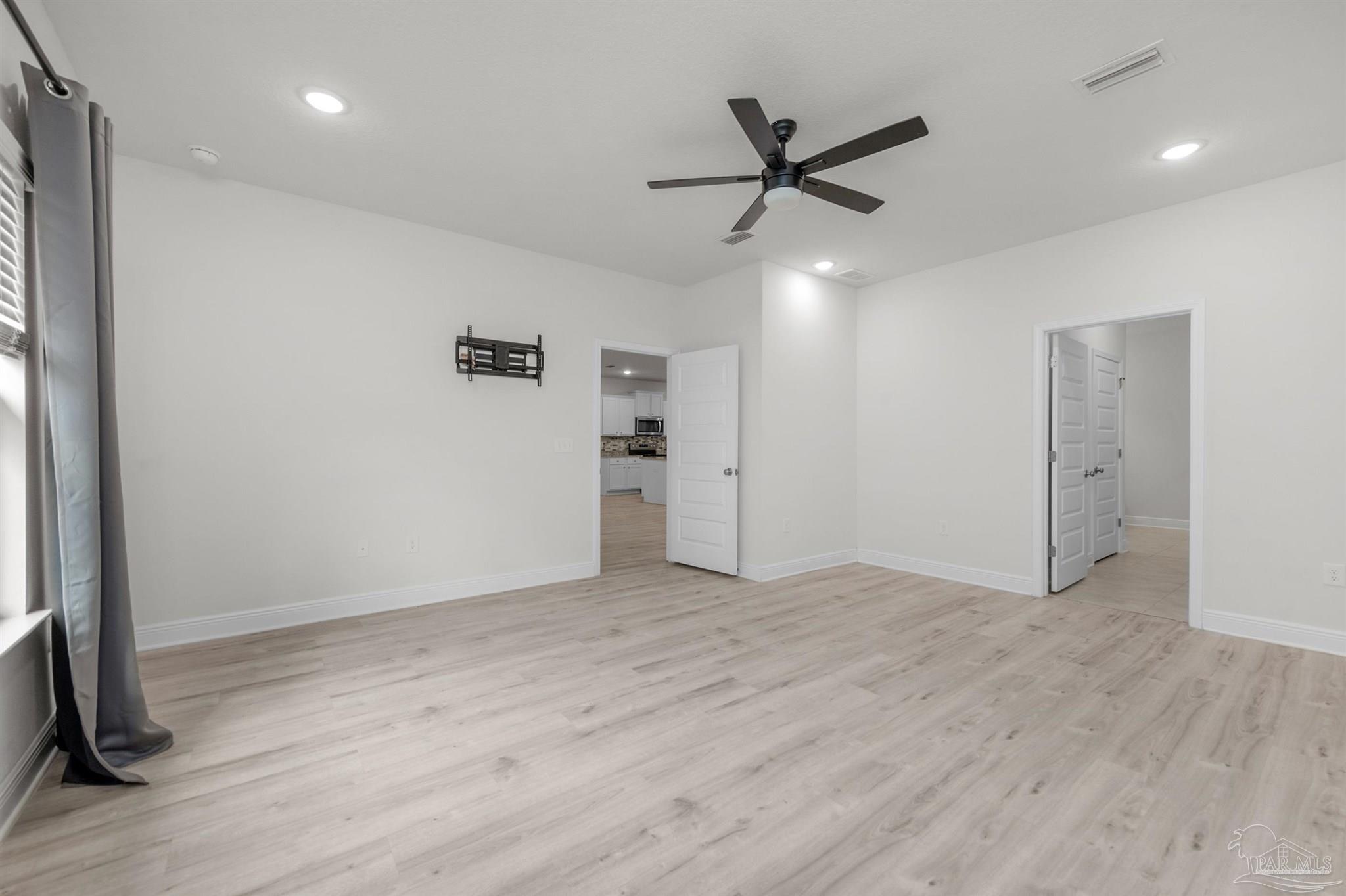 7814 Burnside Loop Pensacola, FL 32526 - Photo 27 of 41 a view of an empty room with wooden floor and a ceiling fan